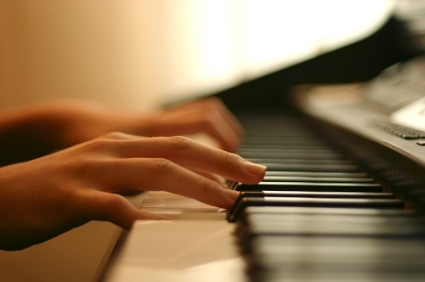 two hands playing on a MIDI keyboard during online piano lesson