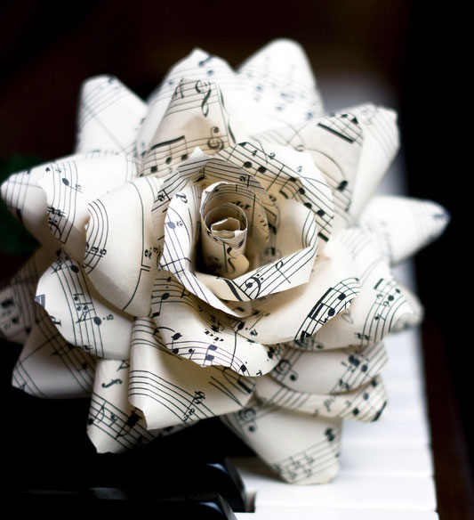paper flower with music staves and notes on piano keyboard