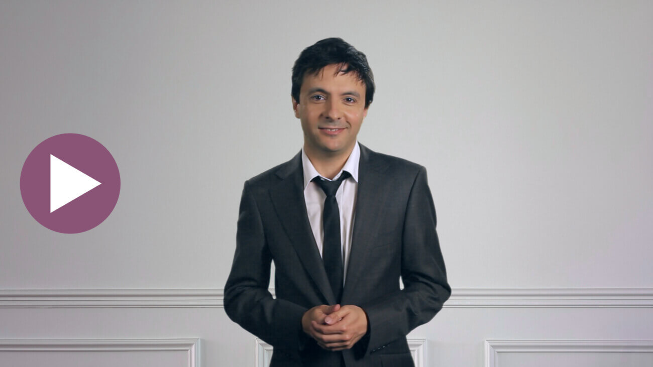 Celebrity pianist and musical director, John Foreman AM, standing and smiling towards camera as he reviews the Musiah AI piano lessons app. Click to view this video.