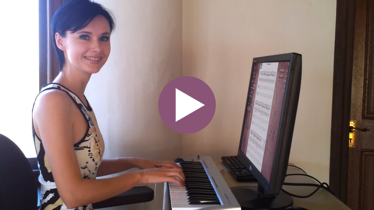 Female adult piano student performing a piece on a MIDI keyboard while following the sheet music in the Musiah piano lessons app on a computer monitor. Click to view the video.